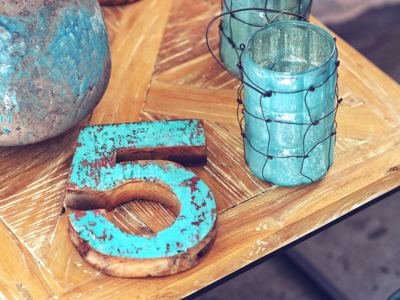 Auf dem Tisch liegt eine blaue Fünf aus Holz. Tara Seymer bietet Numerologie in Paderborn an.